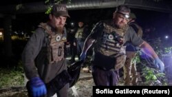 În imagine, echipele de intervenție transportă cadavrul unei persoane ucise într-un atac cu rachete rusesc asupra unei clădiri rezidențiale din Harkov, Ucraina, vineri 31 mai.