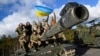 Українські військовослужбовці позують на танку Challenger 2 на військовій базі Bovington Camp на південному заході Великої Британії, 22 лютого 2023 року