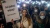 Жена държи плакат с надпис "Нито една повече. Сърцето на Изи също биеше" на протест във Варшава на 6 ноември