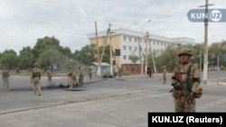 Нөкістегі наразылықты басып-жаншыған күннің ертесінде көшені күзетіп тұрған әскер.