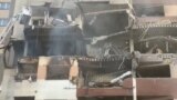 13-июнда Тегеранда Израилдин аба соккуларынан кийин жабыркаган имаратты карап турган адамдар. 