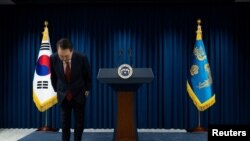 Оңтүстік Кореяның президенті Юн Сок Ель жұрт алдында басын иіп тұр.