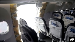 Fotografie publicată de Consiliul Național pentru Siguranța Transporturilor, care arată spațiul lăsat deschis prin desprinderea unei uși în timpul zborului unui Boeing 737 al Alaska Airlines.