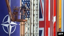 Франция. Страсбургдагы Конгресстер борборунун имаратына НАТОнун саммитин утурлай жумушчулар АКШнын желегин илишүүдө, 2-апрель 2009