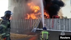 Pompierii ruși lucrează la stingerea unui incendiului la un rezervor de petrolului după un presupus atac ucrainean cu drone asupra regiunii Rostov din Rusia. 18 iunie 2024. Fotografie de arhivă.
