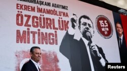 Лідер опозиційної Народно-республіканської партії (НРП) Озгюр Озель на тлі плакату опозиційного мітингу, березень 2025 року