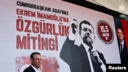 Лидер партии CHP Озгюр Озель на фоне портрета арестованного мэра Стамбула Экрема Имамоглу