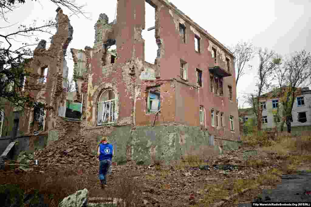 Представник Всесвітньої продовольчої програми стоїть поруч із зруйнованою будівлею у Слов’янську