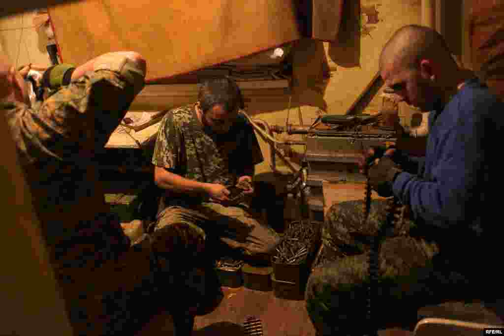 The volunteers prepare their weapons after intelligence reports indicate a heavy night of fighting lies ahead. On the left is Avram, an Orthodox Jew from western Ukraine. The Russian media has portrayed Ukraine's leaders as fascists, but he says he has never experienced anti-Semitism in his country.