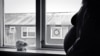 Pregnant woman standing by window