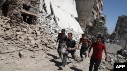 Syrians run for cover during reported government air strikes in the rebel-held town of Douma, east of the capital Damascus late last week. 
