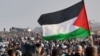 Një person duke valëvitur një flamur palestinez gjatë zhvendosjes së njerëzve në veriun e Rripit të Gazës. Fotografi nga arkivi.