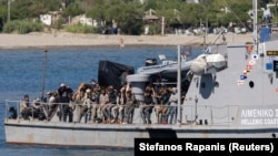 Судно греческой береговой охраны доставляет мигрантов в порт Агия Галини на острове Крит, Греция, 6 июля 2025 года