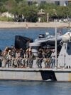 Судно греческой береговой охраны доставляет мигрантов в порт Агия Галини на острове Крит, Греция, 6 июля 2025 года